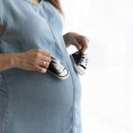 pregnant-woman-playing-with-her-child-s-shoes_23-2148252651
