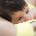 Baby feeds on mother’s breasts milk
