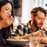 Young couple eating together at home