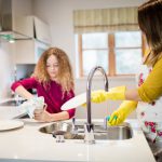 mother-assisting-daughter-washing-plate-kitchen_1170-2831