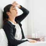 uncomfortable-woman-sits-bed-has-medicine-table_1150-26103
